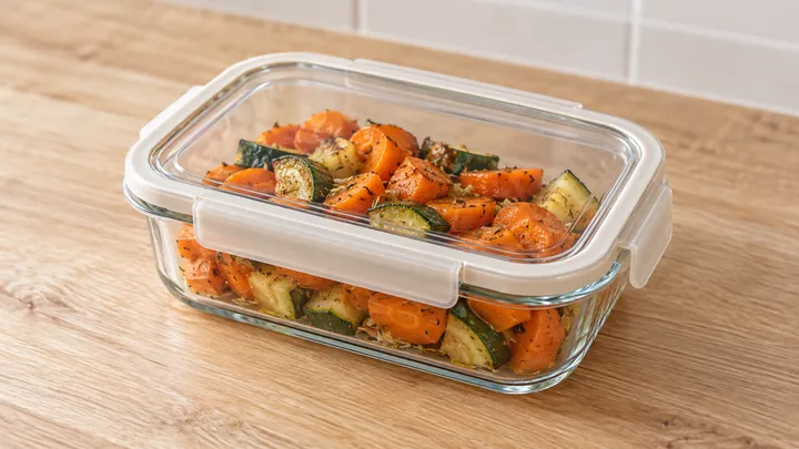 Recipiente de vidrio cerrado con verduras cocinadas